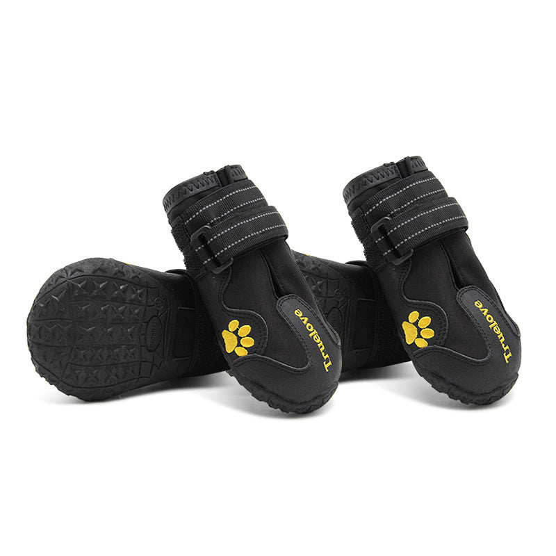 Black dog boots with yellow paw prints on a white background