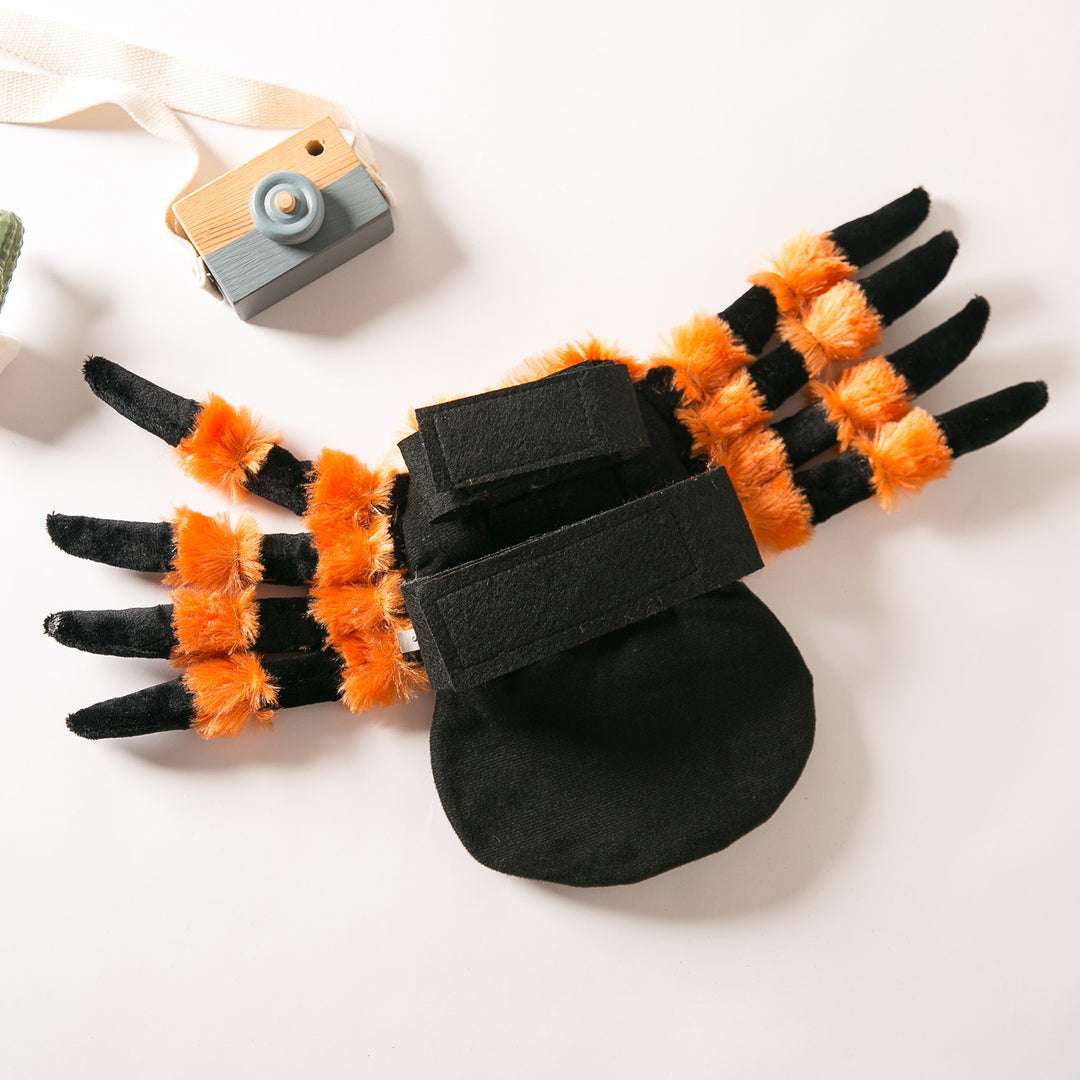 Black and orange spider-like costume for pets on a white background with a small camera.