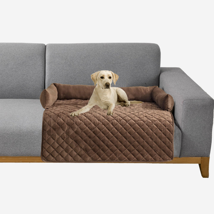 Dog sitting on a brown pet bed attached to a gray couch