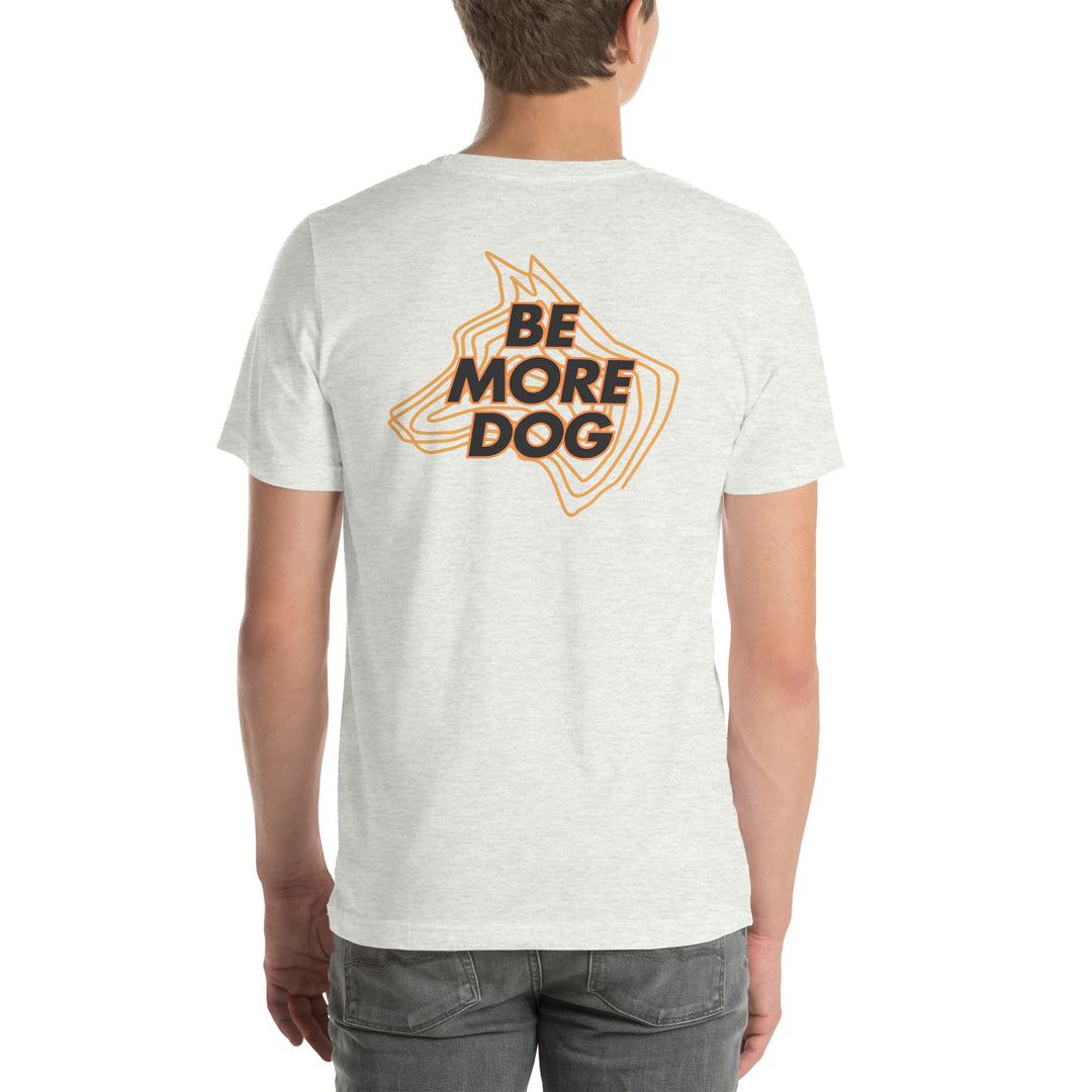 Person wearing an ash white t-shirt with 'Be More Dog' print on the back
