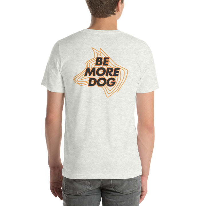 Person wearing an ash white t-shirt with 'Be More Dog' print on the back